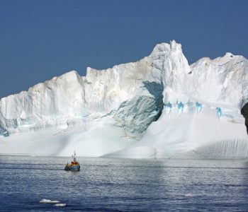 A local fishing boat provides some perspective on the size of the icebergs in Ilulissat icefjord.jpg