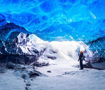 Traveler in ice cave, man standing underground inside of a glacier, climate specific, Vatnajokull National Park, amazing nature of Skaftafell, Iceland